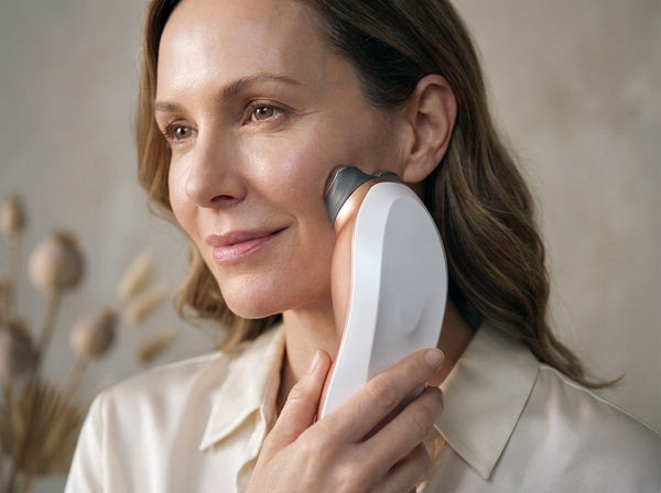 Woman using RF device on cheek, skincare beauty routine, neutral background